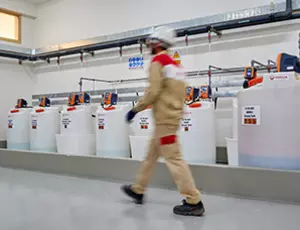 Mann, der neben Kanistern mit Hydrex-Chemikalien läuft