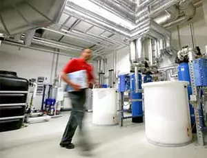 Technischer Mitarbeiter im Technikraum eines Krankenhauses, im Hintergrund Veolia Wassertechnik