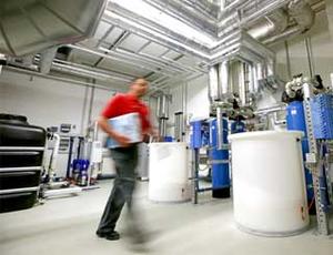 Technischer Mitarbeiter im Technikraum eines Krankenhauses, im Hintergrund Veolia Wassertechnik