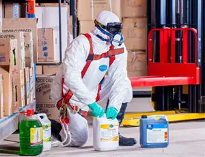 Mensch im Schutzanzug arbeitet mit Chemikalien
