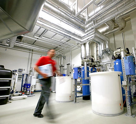 Servicetechniker in einem Keller mit Hauswassertechnik von Veolia