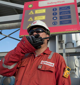 Employee 2 with safety gear talking in a walkie-talkie