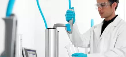 Labormitarbeiter entnimmt Reinstwasser aus ELGA PURELAB flex System