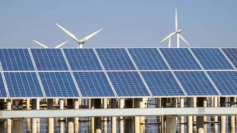 Solarzellen mit Windkrafträdern im Hintergrund