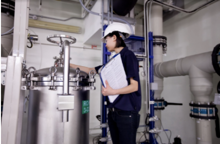 Femme observant les stations de traitement de l'eau ultra-pure et des eaux usées de la fabrique de plaquettes de Soitec.