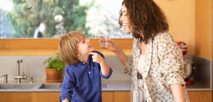 Frau und Kind mit einem Glas Trinkwasser
